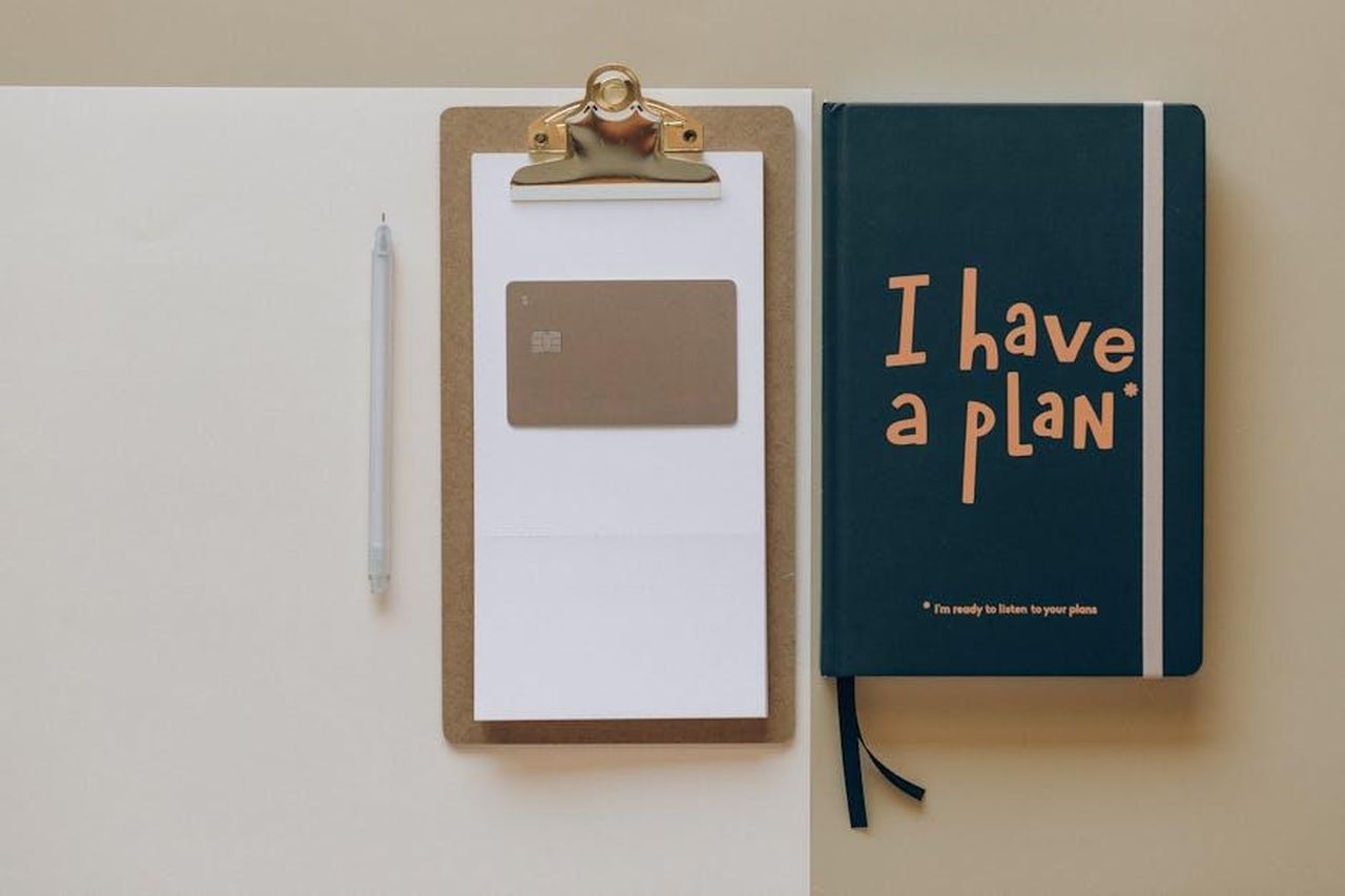 Altre_nomine_chiave_nel_management_35opYrB3Ju - Veicoli24 Source: Nataliya Vaitkevich - pexels - A minimalist office setup featuring a planner, clipboard, card, and pen, perfect for planning and organization.
