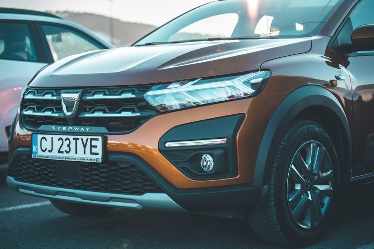 Caratteristiche_chiave_del_design_di_Avenger_4xe_2fyzVdh9K2 - Veicoli24 Source: Emanuel Turbuc - pexels - Close-up of a brown Dacia Stepway car showcasing its front grille and headlights.
