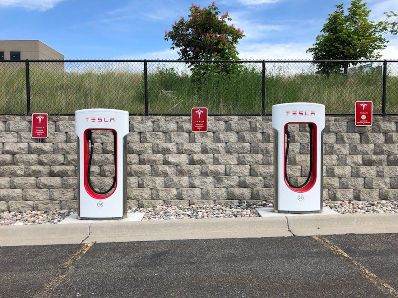 Caratteristiche_dellAbarth_500e_33BeHcNcch - Veicoli24 Source: Chad Russell - pexels - Dual Tesla electric car chargers in Idaho Falls parking lot with clear blue sky.