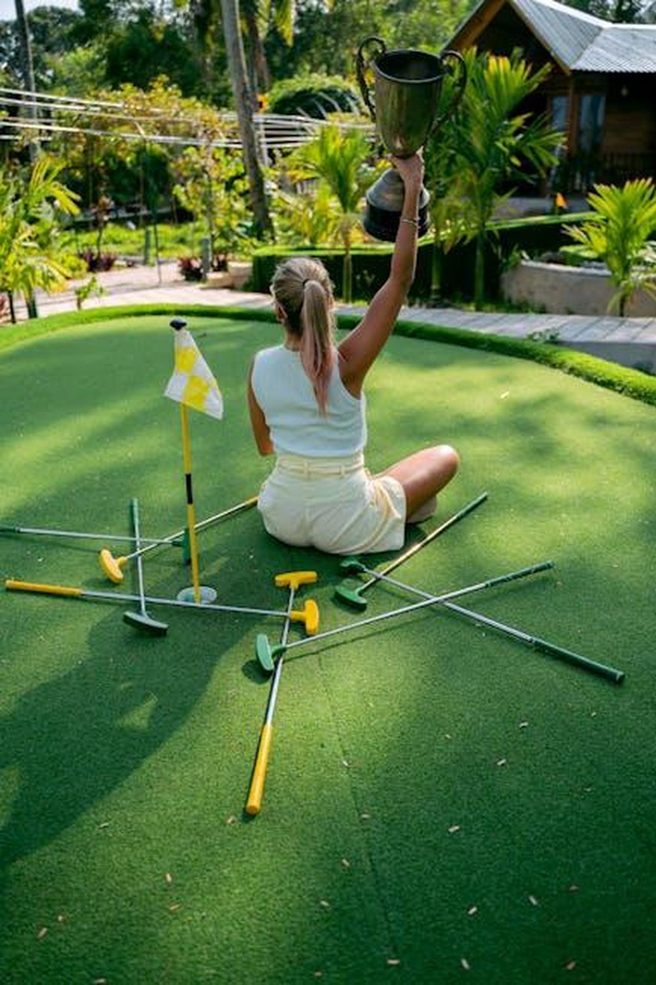 Colin_Montgomerie_presenta_i_trofei_ai_vincitori_9T03uJIXoV - Veicoli24 Source: Anna Tarazevich - pexels - Woman holding a trophy while sitting on a mini golf course, celebrating a victory.