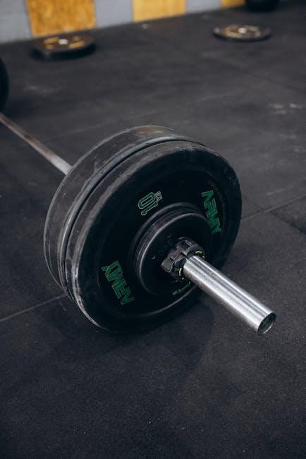 Collaborazione_con_Differenza_Donna_4cyMqJHPk4 - Veicoli24 Source: Jonathan Borba - pexels - Close-up of a heavy barbell with weight plates on a gym floor, ideal for strength training and bodybuilding.