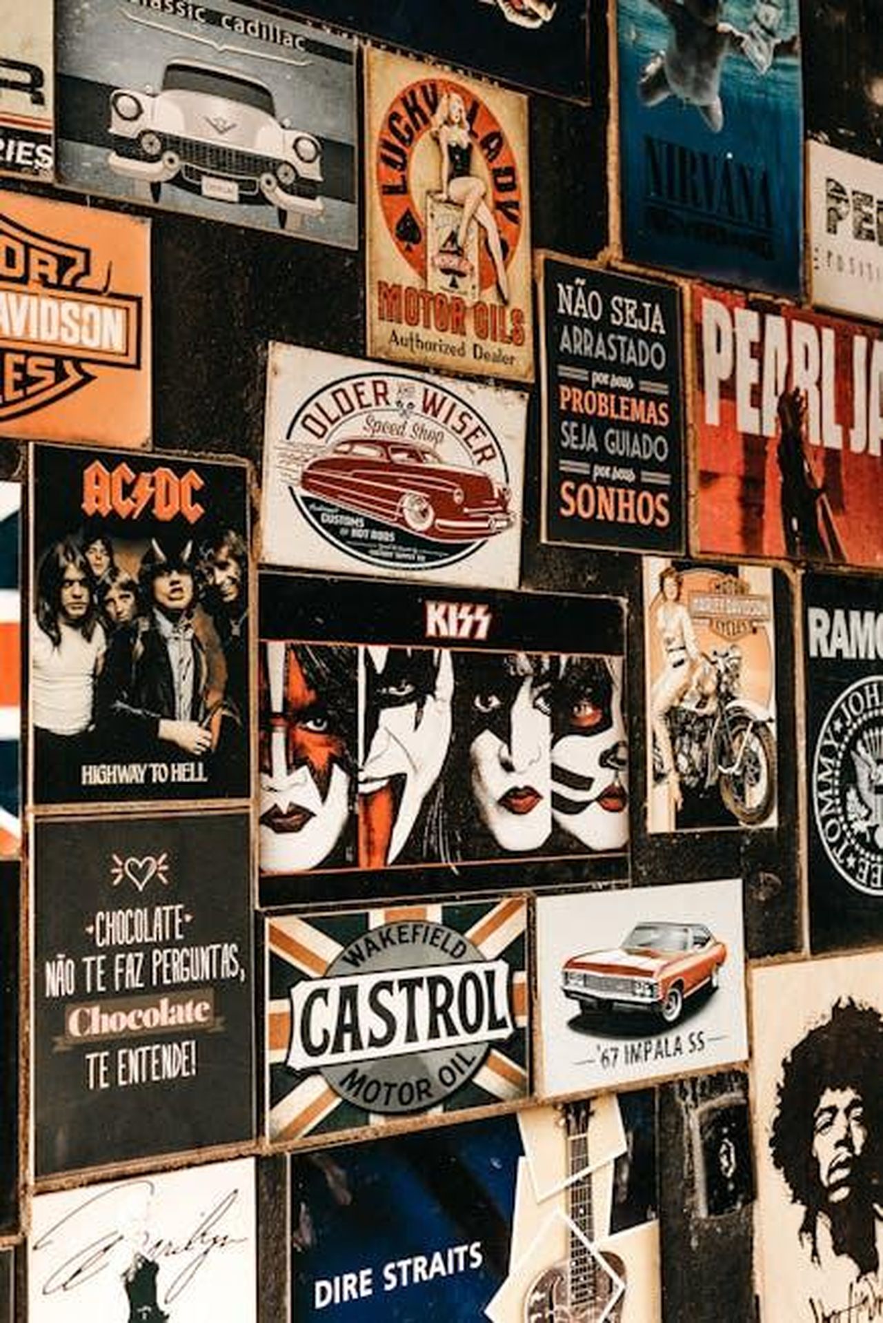 Colori_attraenti_per_un_look_distintivo_vqHafWNRwS - Veicoli24 Source: Jonathan Borba - pexels - A collage of iconic rock band posters and vintage advertisements on a textured wall.