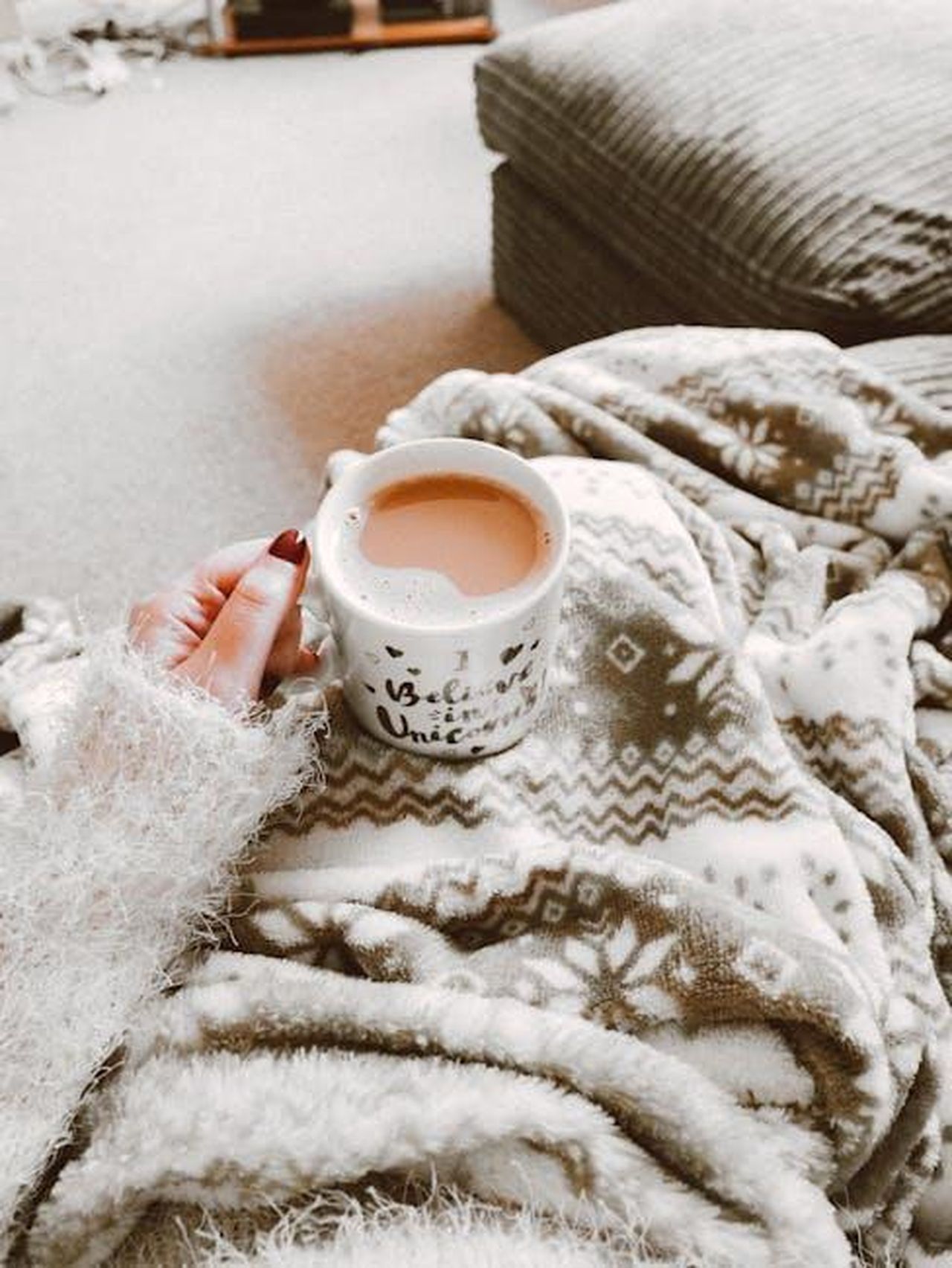 Comfort_e_qualit_C3f28oViQq - Veicoli24 Source: Lisa from Pexels - pexels - Person holding a hot drink surrounded by cozy blanket indoors. Perfect for winter comfort.