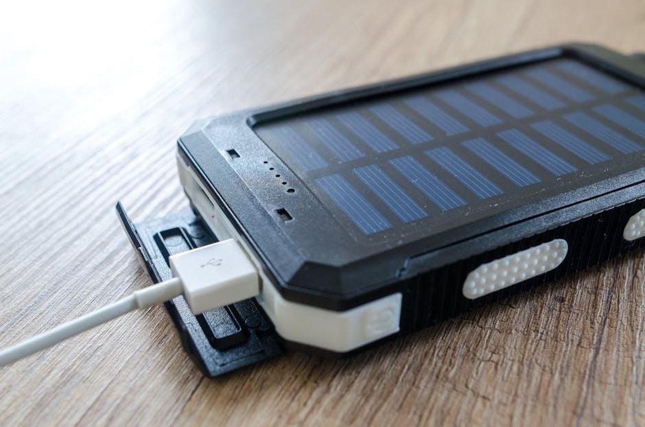 Competizione_nel_settore_delle_batterie_a_stato_solido_jEkx355HsS - Veicoli24 Source: Lukas - pexels - A close-up of a solar charger with a USB connection on a wooden surface, showcasing modern technology.