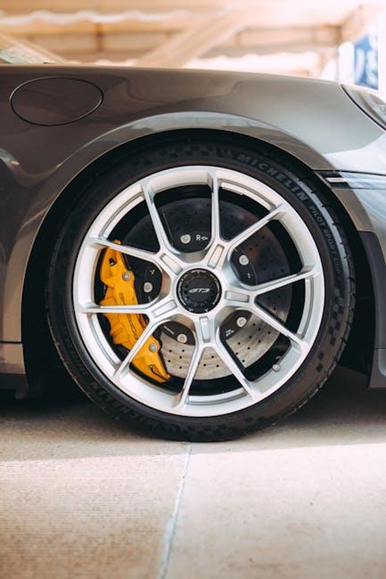 Consultazioni_con_i_produttori_e_implementazione_dei_sensori_vZRJf7o4Om - Veicoli24 Source: Rodrigo Chablé - pexels - Detailed view of a sports car wheel featuring a prominent yellow brake caliper.
