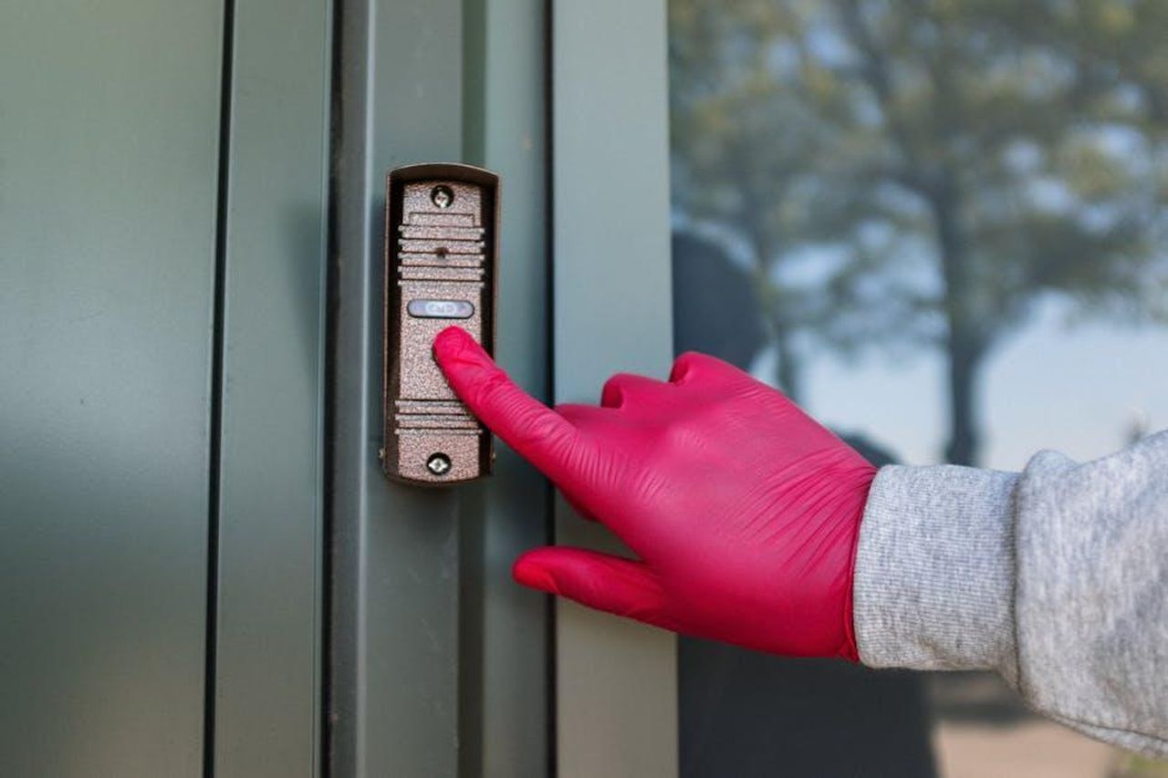 Contatto_Stampa_JOgigxw26V - Veicoli24 Source: cottonbro studio - pexels - A red gloved hand presses a modern doorbell on a metal door, depicting security and service.