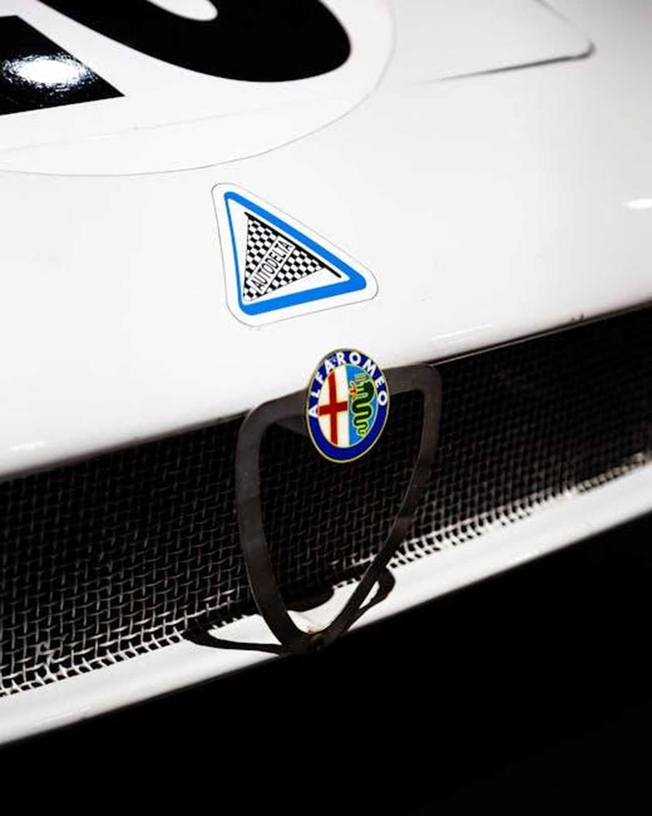 Crescita_di_Alfa_Romeo_a_febbraio_2025_uGS0taJt1H - Veicoli24 Source: Quentin Martinez - pexels - Close-up of an Alfa Romeo emblem on a classic car, emphasizing vintage design.