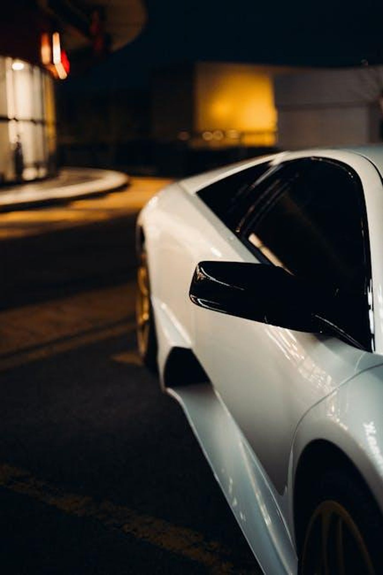 Design_e_comfort_della_Nuova_Ypsilon_5Pyy1414p7 - Veicoli24 Source: Borta - pexels - Stylish white sports car with black accents parked under city lights at night.