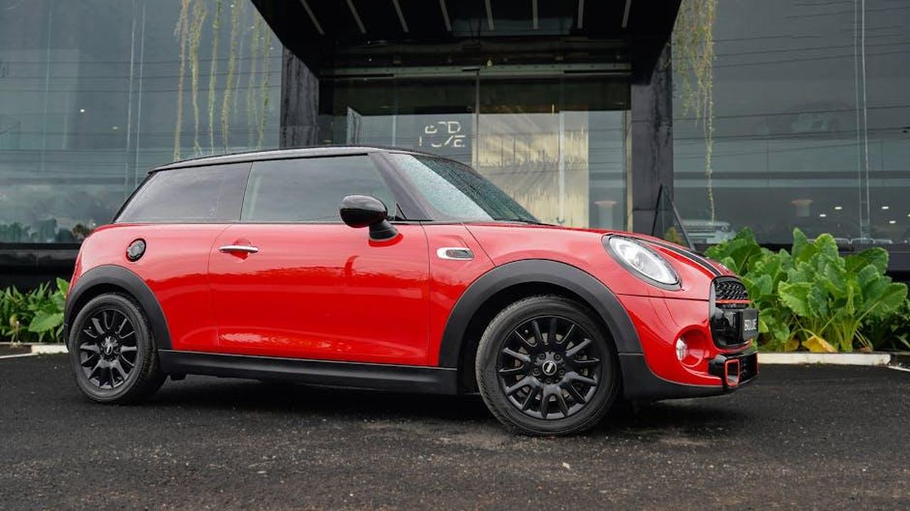 Dettagli_sulla_BMW_Group_e_la_sua_strategia_RDE8Gd8R7v - Veicoli24 Source: AMBADY KOLAZHIKKARAN - pexels - Red Mini Cooper parked outside modern building on rainy day.
