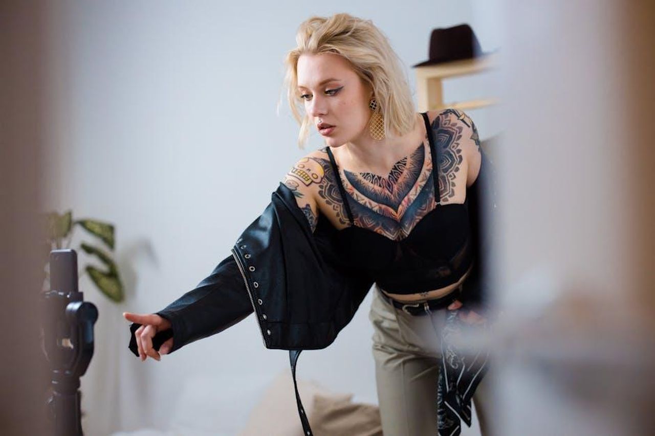 Dettagli_sulla_diretta_della_conferenza_Cu3MNORmeT - Veicoli24 Source: Ron Lach - pexels - A fashionable woman with tattoos streaming video indoors.