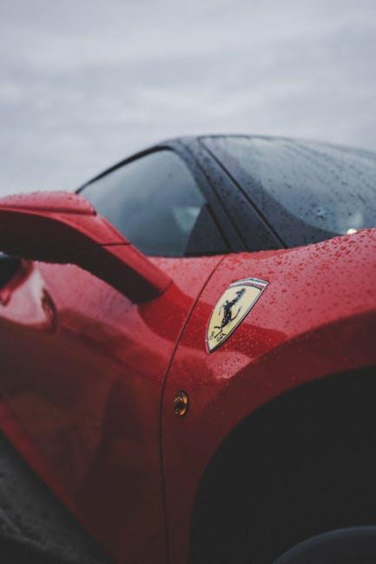 Efficienza_aerodinamica_della_DS_N8_vzxHw2ASRL - Veicoli24 Source: Zachary DeBottis - pexels - Detailed close-up of a red luxury sports car featuring rain droplets and emblem, evoking speed and elegance.