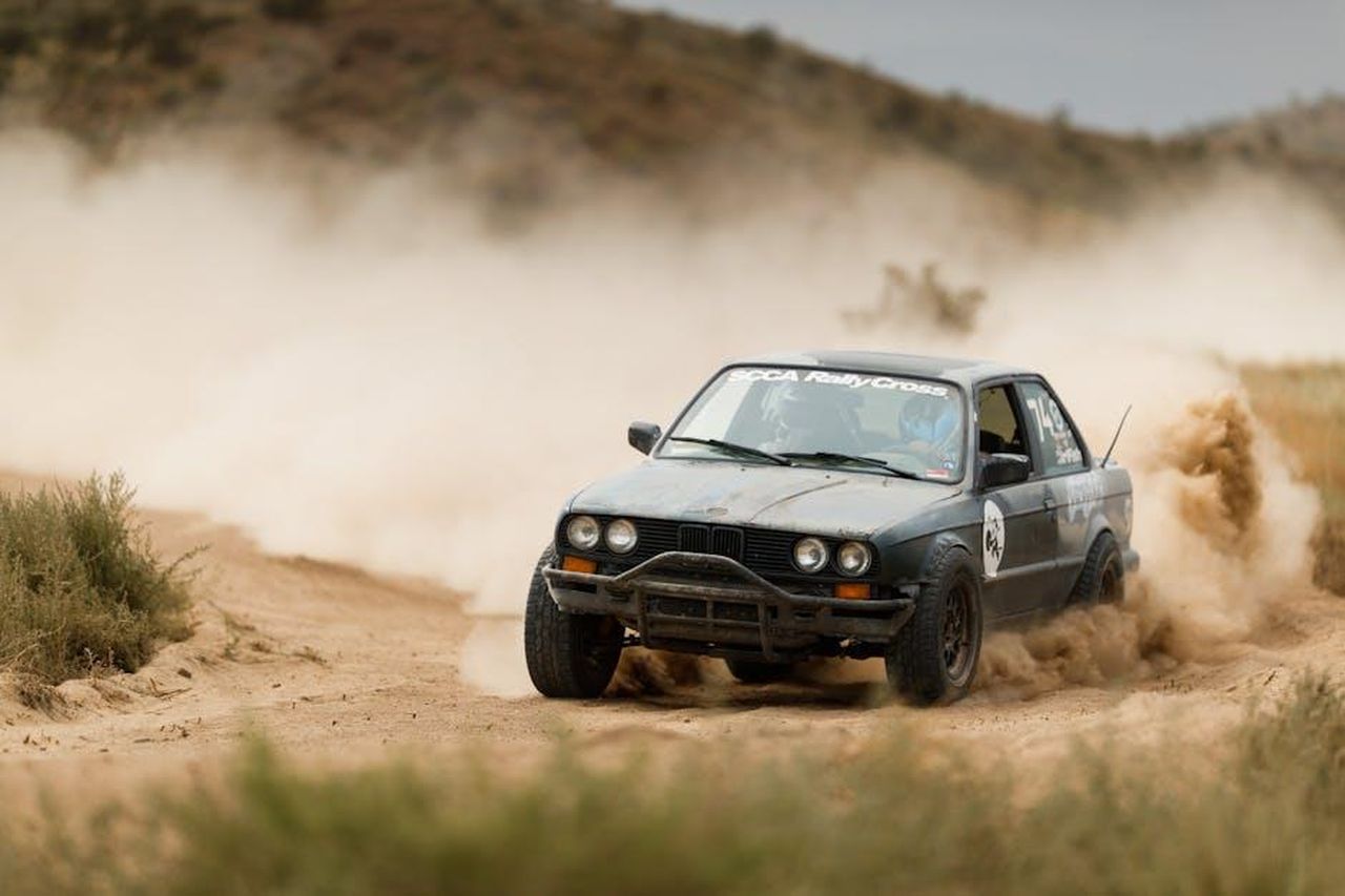 Elfyn_Evans_e_la_sua_performance_costante_9M7VlGa7zS - Veicoli24 Source: Leif Bergerson - pexels - An off-road rally car speeds through the sandy terrain, creating a dramatic dust trail.