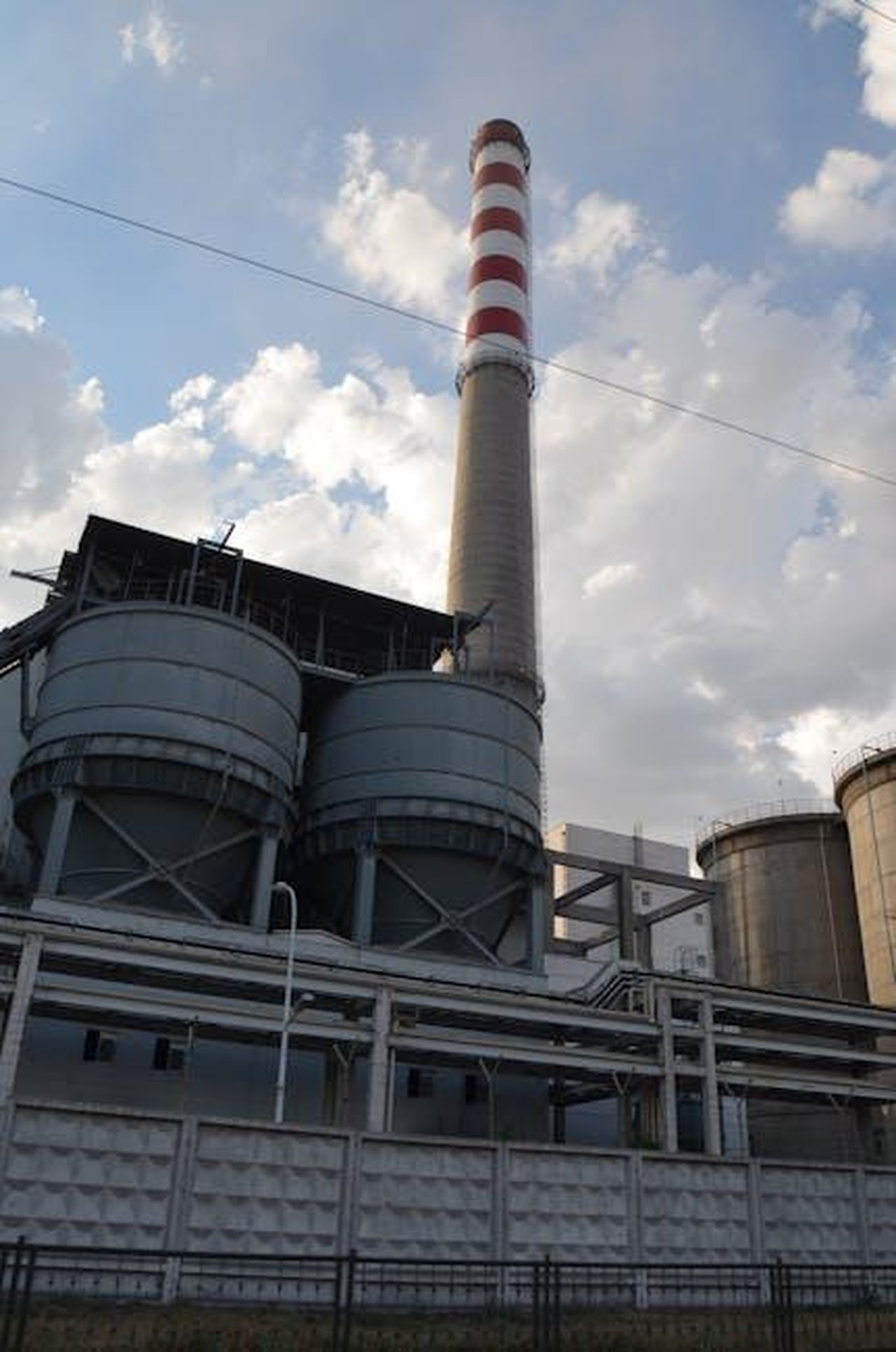 Emissioni_di_CO2_e_Consumo_lm7yX3UtBM - Veicoli24 Source: Daryana Vasson - pexels - Industrial factory with towering chimney against cloudy sky.