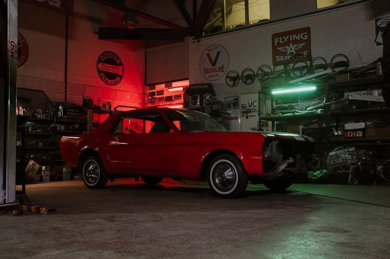 Evoluzione_delladozione_dei_veicoli_elettrici_CaQ6jNysOR - Veicoli24 Source: cottonbro studio - pexels - Vintage red car in an atmospheric auto shop with neon lights and vintage signs.