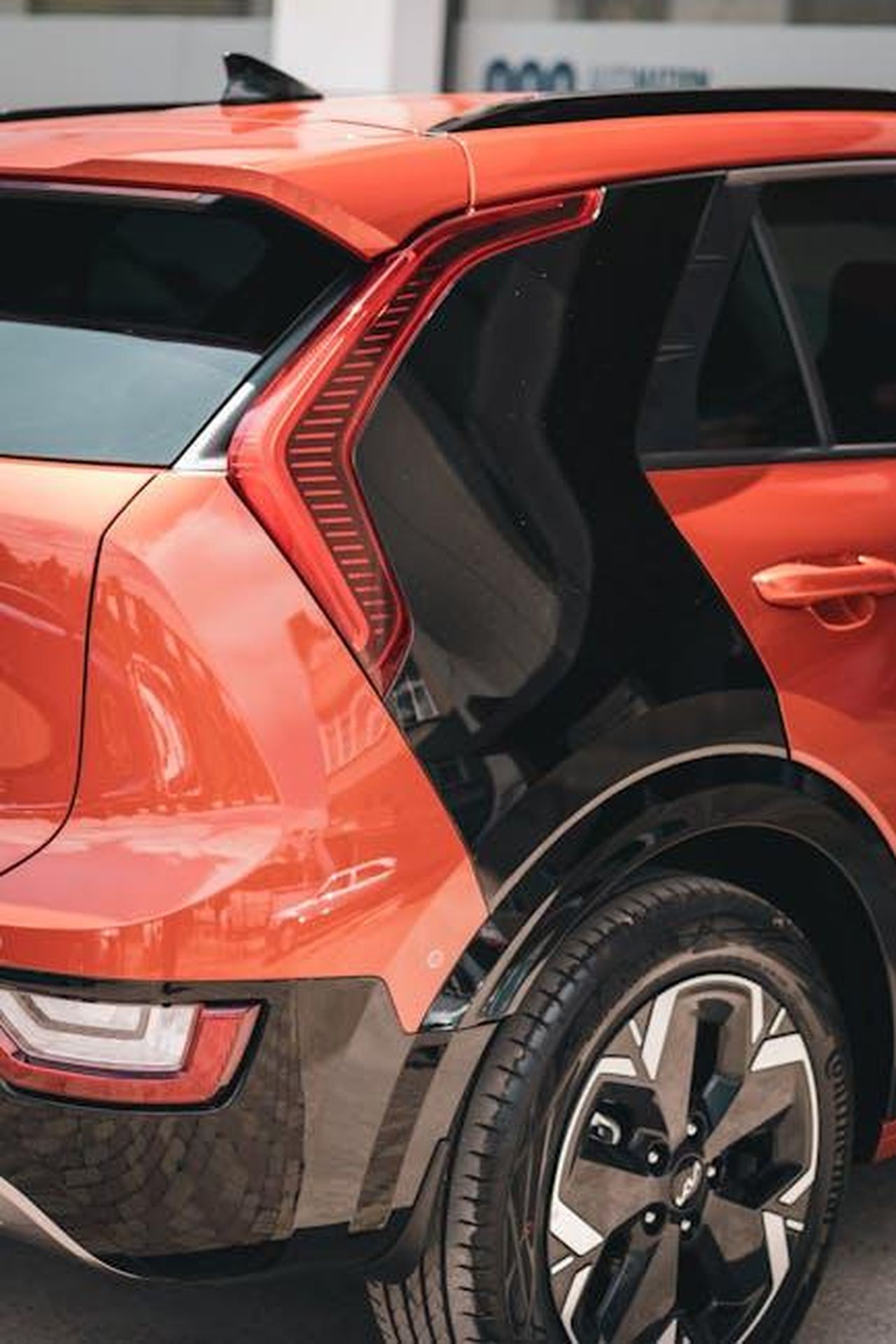 Fattori_che_influenzano_laumento_dei_prezzi_XkLA4FGQ4a - Veicoli24 Source: Caner Demiroğlu - pexels - Red Niro sports car showcased in an urban environment, highlighting sleek design and style.