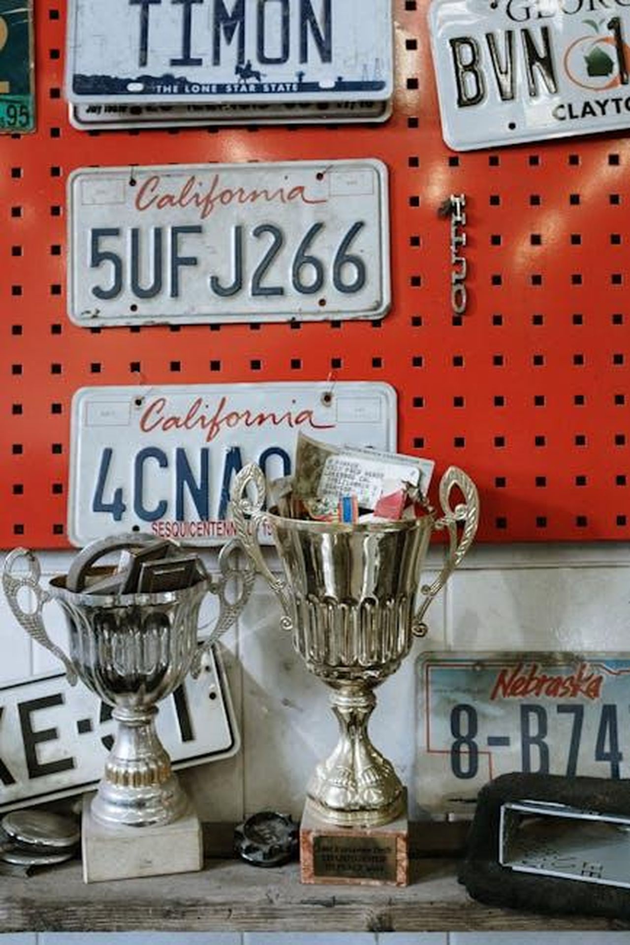 Gamma_e_prezzi_della_DS_N8_cGx2w0UHKt - Veicoli24 Source: cottonbro studio - pexels - A collection of vintage license plates and shiny trophies on a workshop wall.
