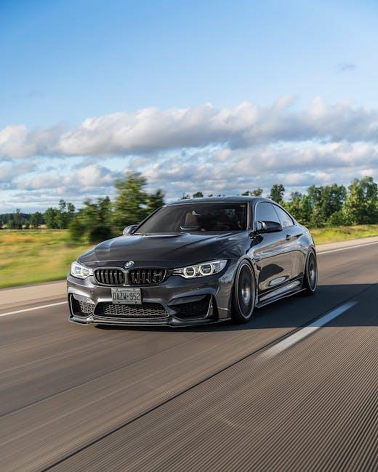 I_piloti_di_ROWE_Racing_per_la_24h_Nrburgring_TFVceUIicZ - Veicoli24 Source: Bradley De Melo - pexels - A sleek BMW M4 speeds down an open highway under clear skies, showcasing automotive design and performance.