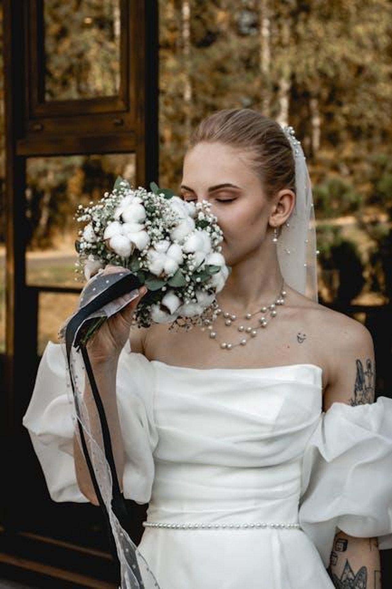 Impegno_di_Lancia_contro_la_violenza_di_genere_ETMeP9vpEp - Veicoli24 Source: Владимир Высоцкий - pexels - Bride holding a floral bouquet, showcasing elegance in a white wedding dress.