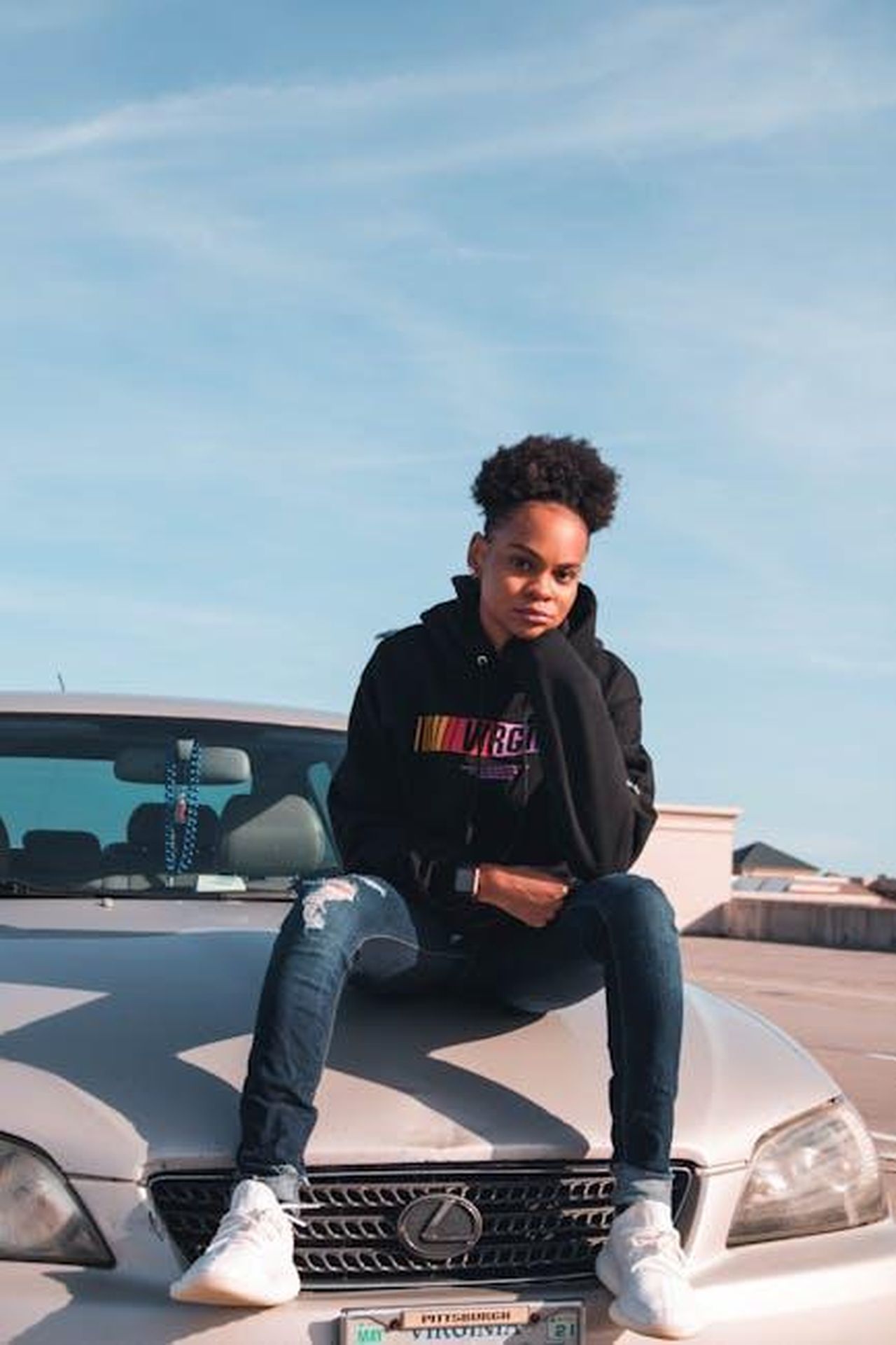 Informazioni_aggiuntive_sulla_gamma_Lexus_rZAxNSPpRK - Veicoli24 Source: Tnarg - pexels - Person in casual wear sits on car hood in an urban outdoor setting, showcasing street fashion.