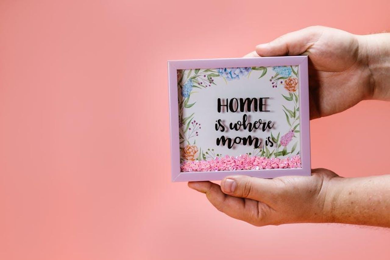 Jeep_Avenger_4xe_The_North_Face_Edition_468OyBCzuo - Veicoli24 Source: RDNE Stock project - pexels - Hands holding a floral shadow box with 'Home is where mom is' text, perfect for Mother's Day gifting.