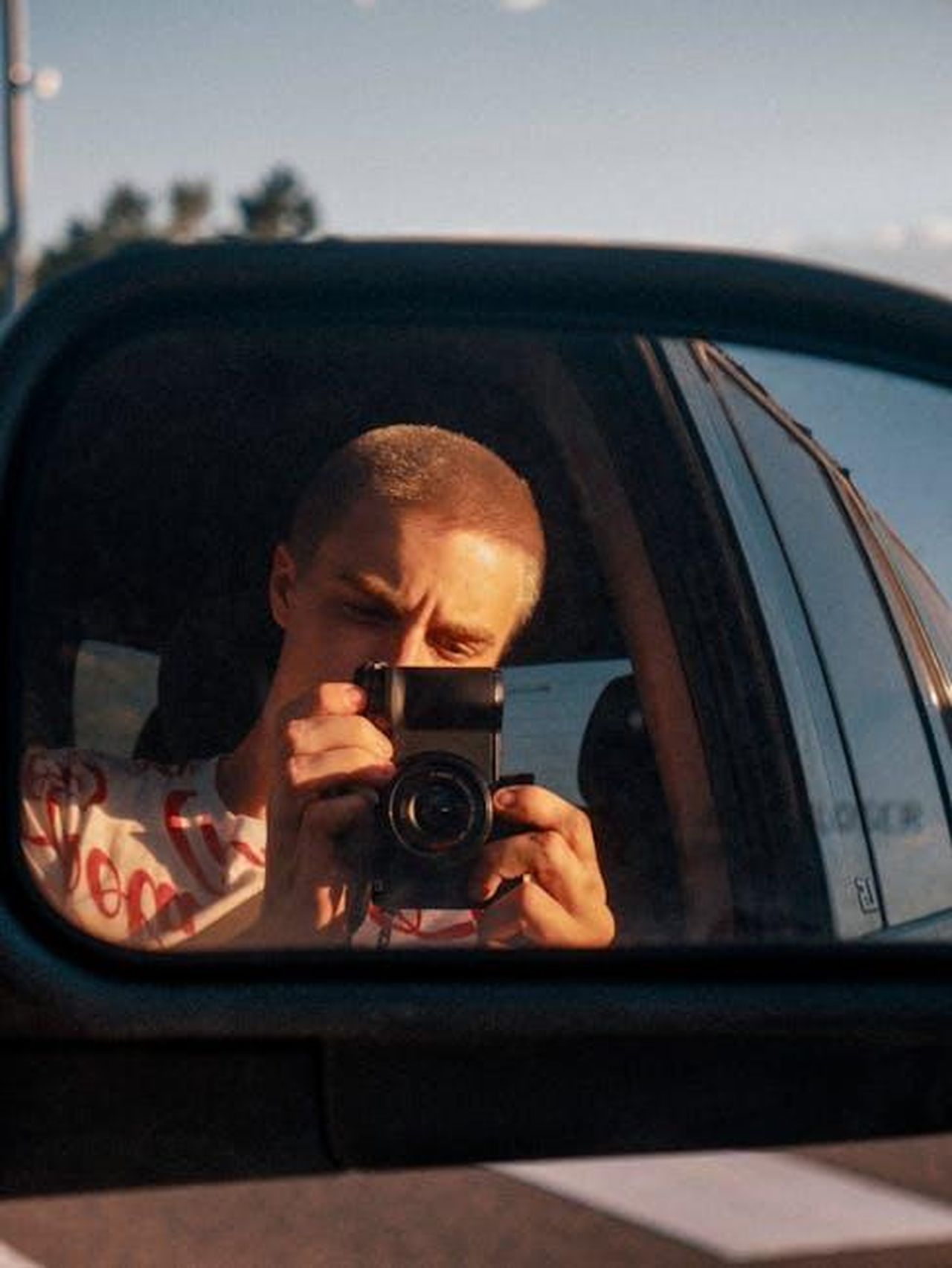 La_Lucid_Air_2025__una_buona_auto_UN5yzkmdmo - Veicoli24 Source: Aidan Roof - pexels - A photographer captures a self-portrait using a car's side mirror at golden hour.