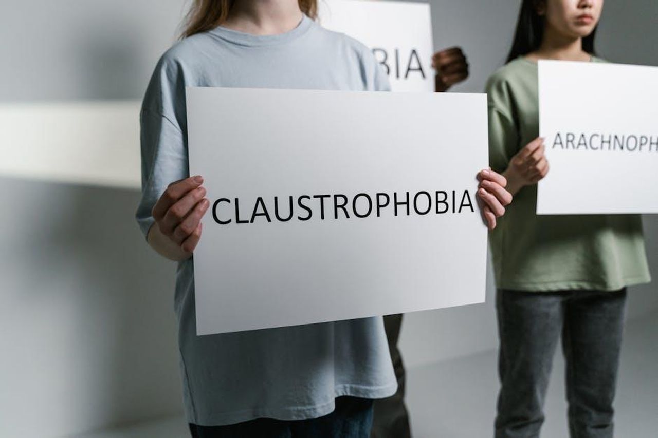 La_campagna_social_di_Fiat_e_Amici_BF5KRTiSbx - Veicoli24 Source: MART PRODUCTION - pexels - Group of individuals holding signs displaying phobia names in a neutral setting.