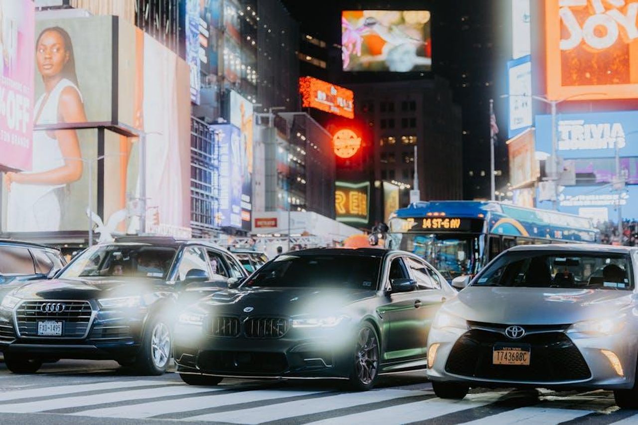 La_guerra_pubblicitaria_tra_Audi_e_BMW_F5uG2tS81p - Veicoli24 Source: Luke Miller - pexels - Cars and bright billboards illuminate a busy city nightlife scene, capturing urban energy and vibrancy.