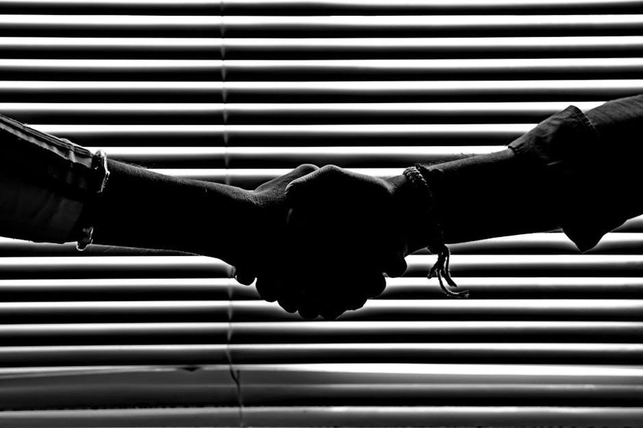 La_partnership_tra_Lancia_e_Cassina_lM8MKslBZ5 - Veicoli24 Source: Savvas Stavrinos - pexels - Silhouette of two people shaking hands symbolizing partnership and trust.