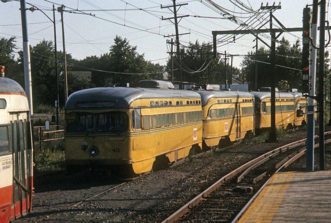 La_visione_Empact_di_Toyota_GJnGqP6RLQ - Veicoli24 Source: Bill Silveira - pexels - A historic yellow streetcar travels along a tramway in Cleveland, Ohio, surrounded by lush greenery.