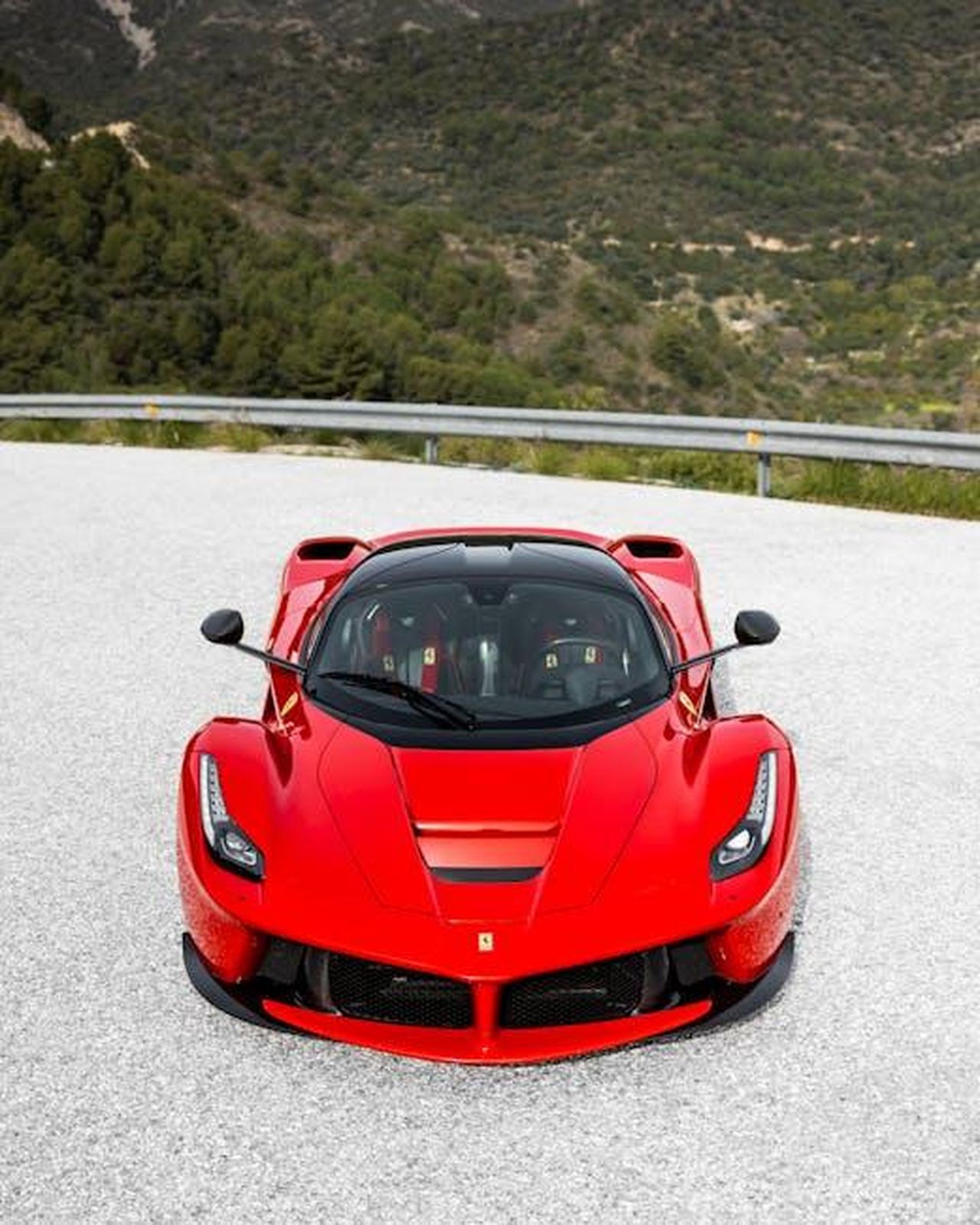Le_ambizioni_di_Schubert_Motorsport_87pq052PAM - Veicoli24 Source: Quentin Martinez - pexels - Vibrant red sports car parked on a scenic mountain road under clear skies.