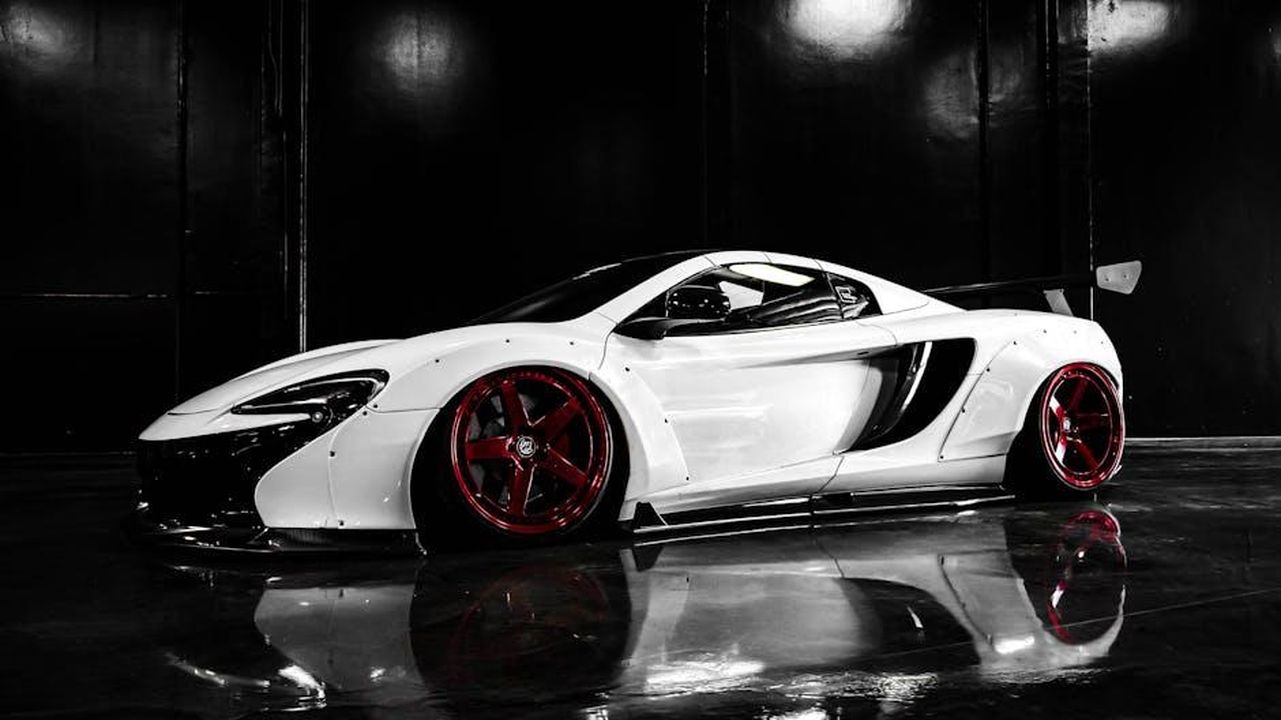 Le_dichiarazioni_delle_aziende_zX8eGEu4ui - Veicoli24 Source: jae p - pexels - Modern luxury sports car with custom red wheels in a showroom.