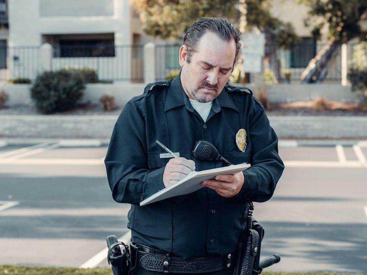 Le_ragioni_della_fine_della_produzione_NpiwqXqmRz - Veicoli24 Source: Kindel Media - pexels - Police officer in uniform writing a ticket on a clipboard outdoors.