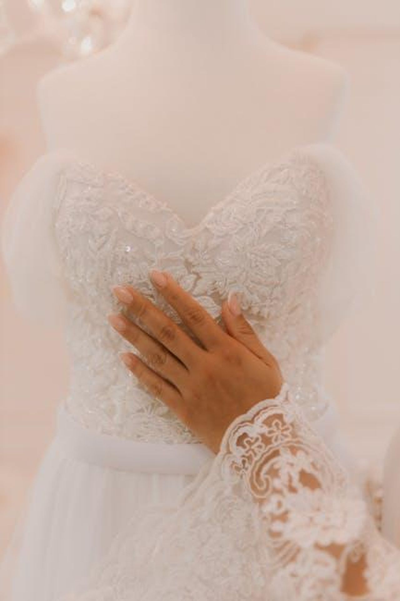 Lindividualizzazione_come_espressione_delle_nostre_personalit_u2KmDAXH9P - Veicoli24 Source: Alexander Mass - pexels - A hand touching a stunning lace wedding gown, showcasing intricate bridal fashion design.