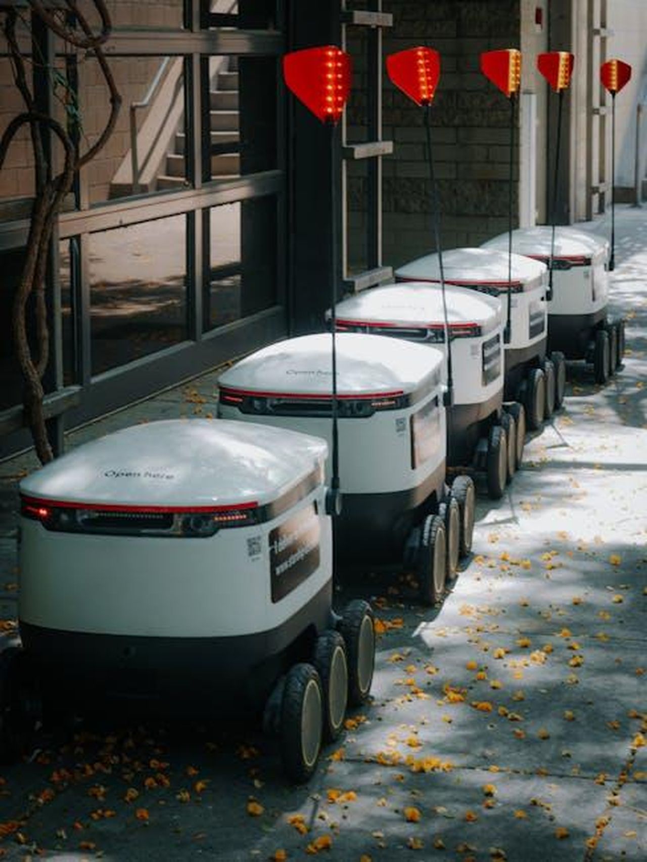 Maserati_e_Stellantis_il_futuro_della_guida_autonoma_ZJd8FJh4Fy - Veicoli24 Source: Kindel Media - pexels - Line of autonomous food delivery robots on urban path under trees.