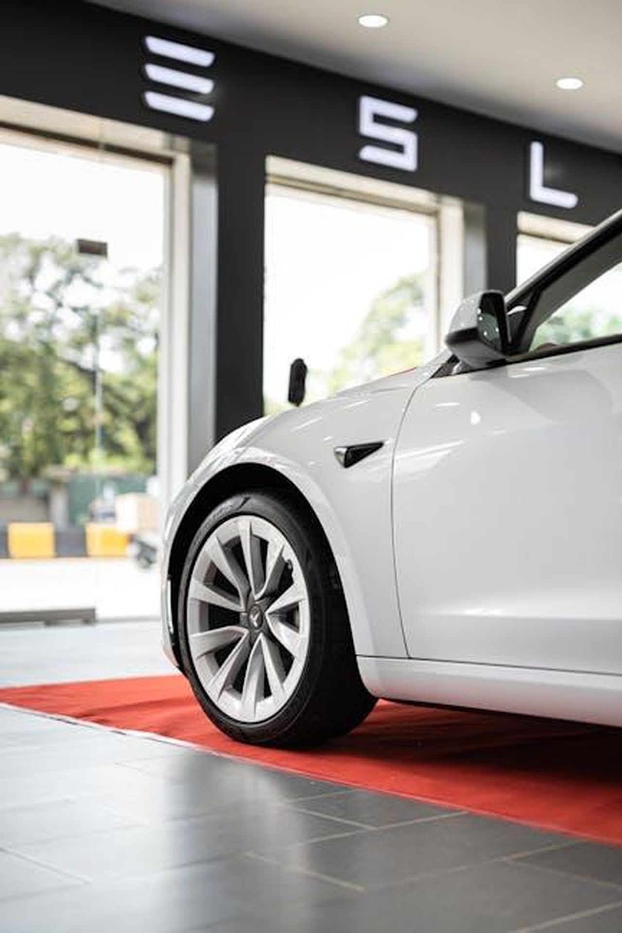 NEUE_KLASSE_Il_Futuro_della_Mobilit_n8HBcLAte0 - Veicoli24 Source: I'm Zion - pexels - Close-up of a white electric car parked on a red carpet indoors, showcasing luxury and innovation.