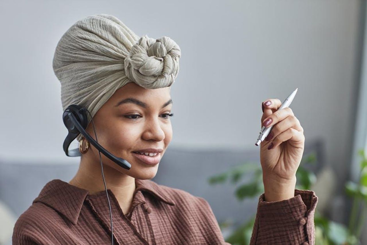 Nuovo_assistente_virtuale_MBUX_AwmuVPWIqY - Veicoli24 Source: Jep Gambardella - pexels - Smiling woman wearing a headset while working at a call center, looking engaged and professional.