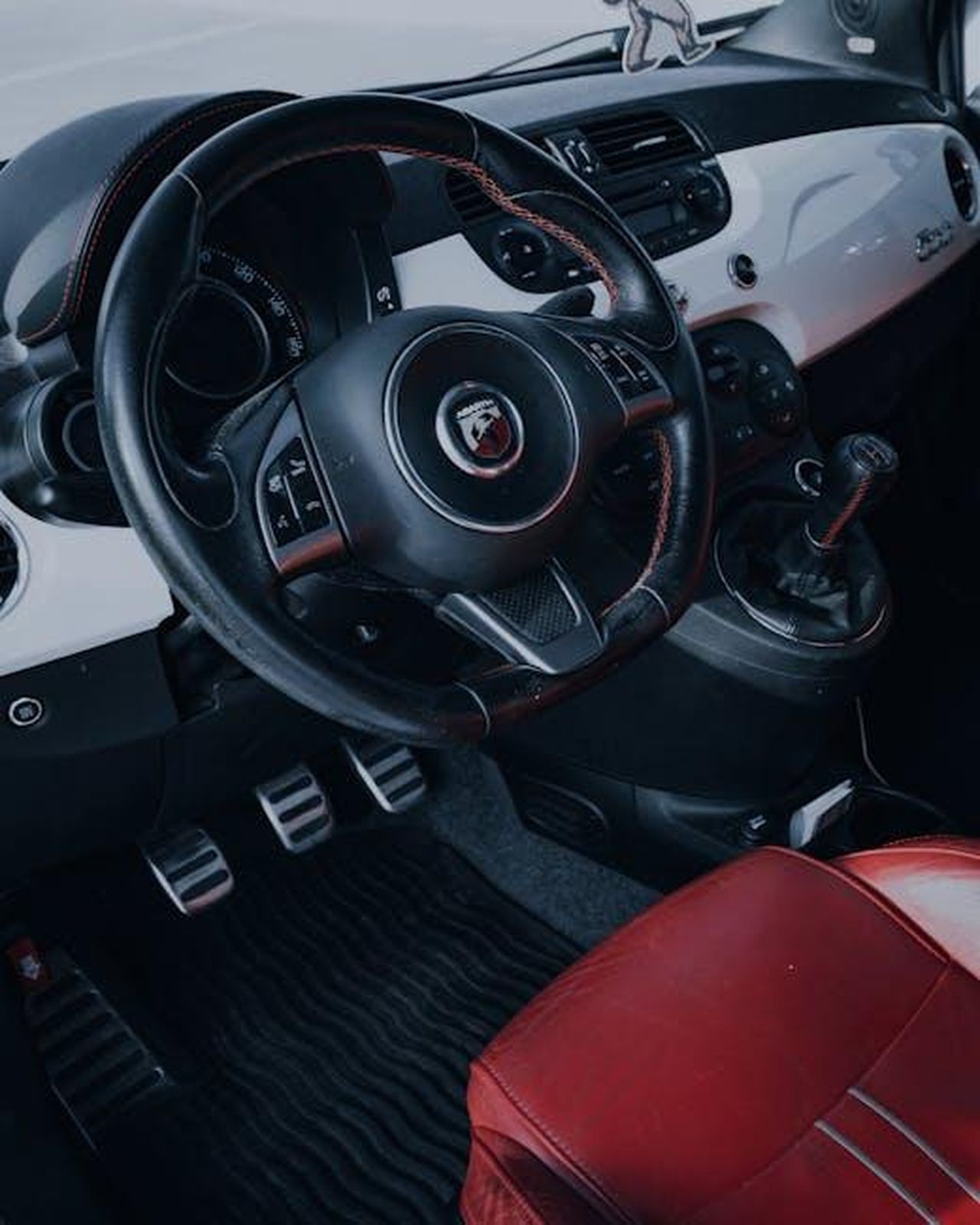 Premi_e_riconoscimenti_per_lAbarth_500e_nY52TNFlXk - Veicoli24 Source: Eric Hammett - pexels - Detailed view of a Fiat 500 Abarth interior featuring steering wheel and gearshift.