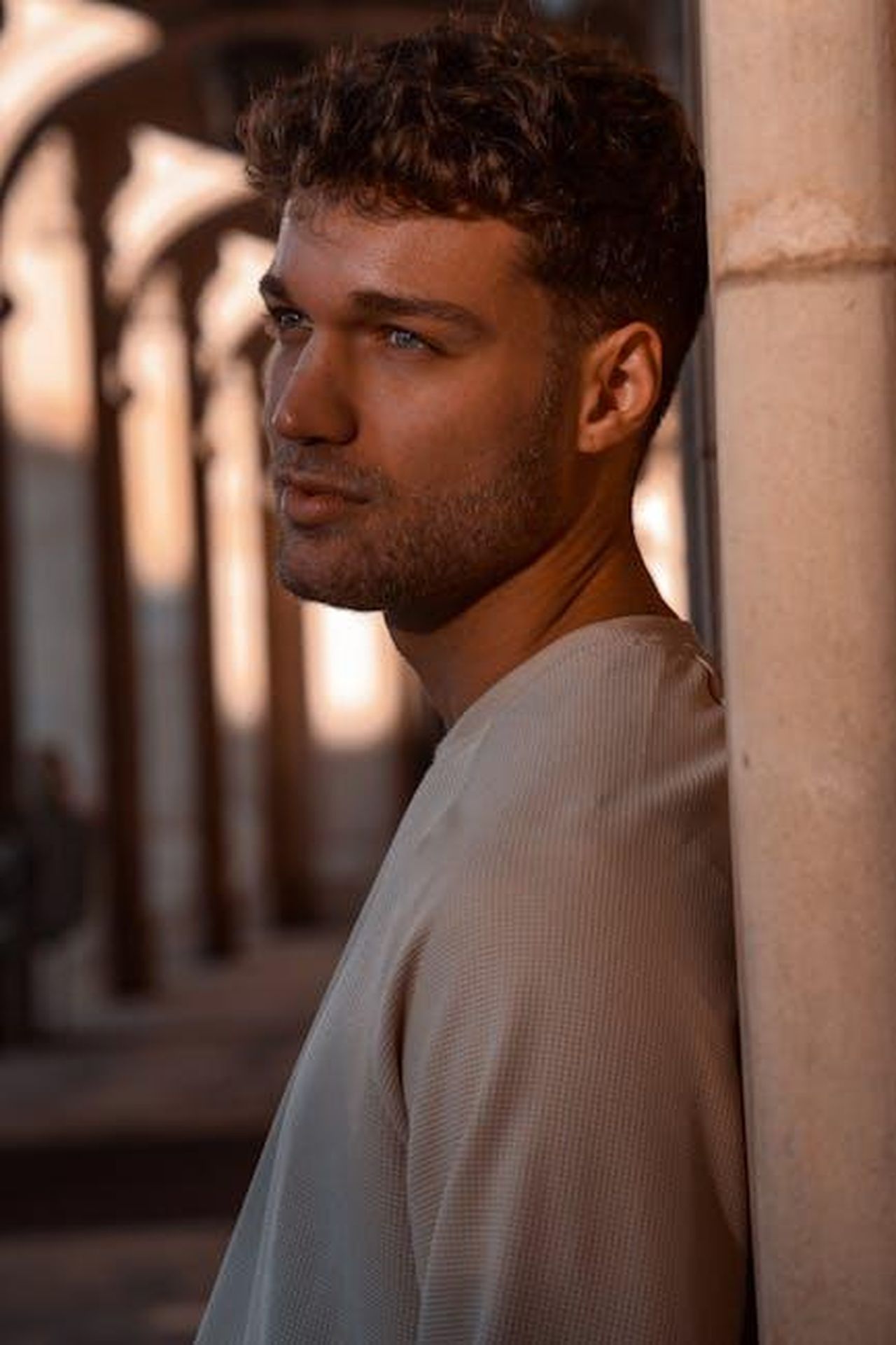Preparazione_per_la_nuova_generazione_di_modelli_7IYOIKcCT7 - Veicoli24 Source: Dave Tombi - pexels - Portrait of a contemplative man leaning against a pillar, bathed in sunset light.