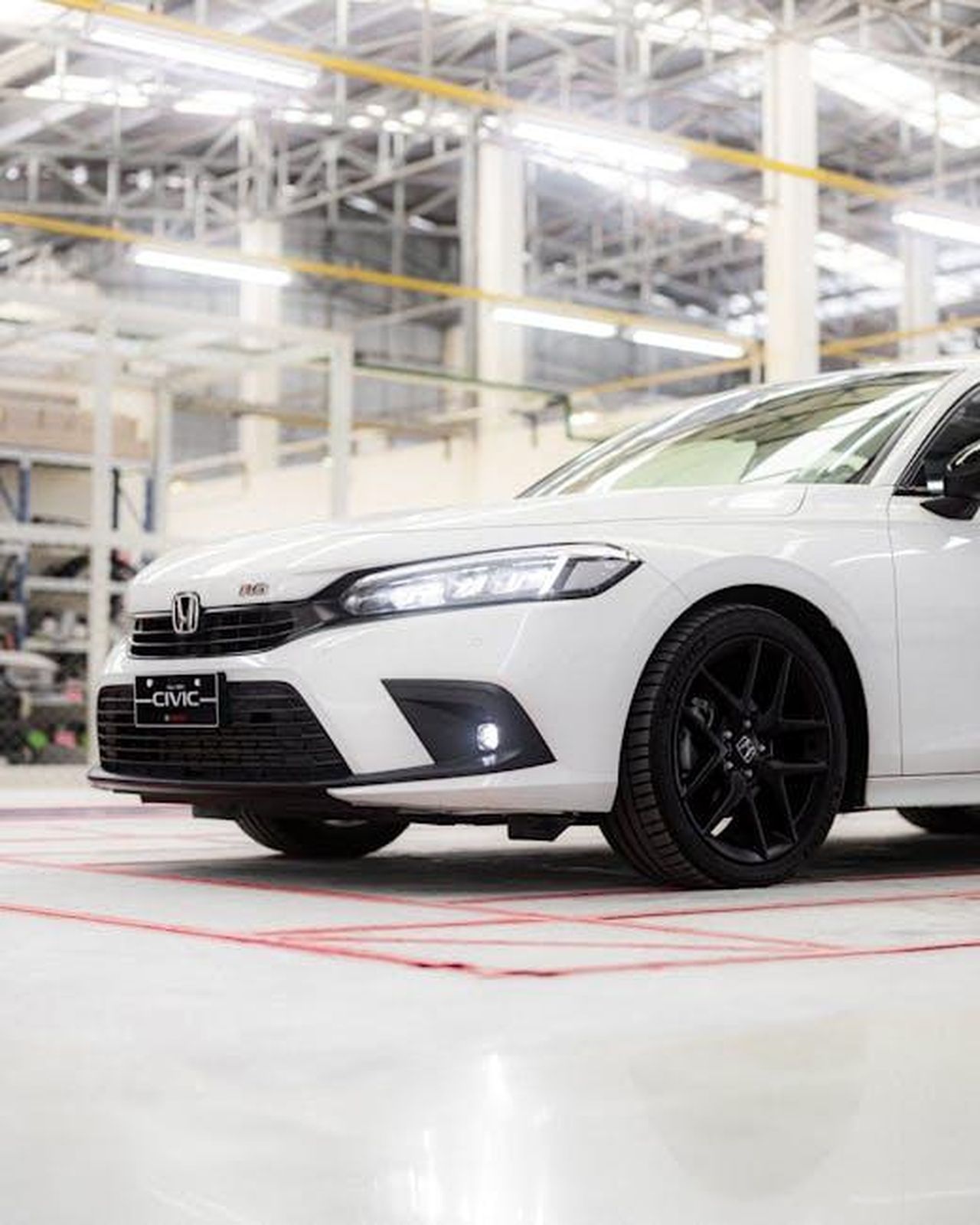 Produzione_e_incentivi_per_il_Honda_Prologue_ssp5QLnxdU - Veicoli24 Source: I'm Zion - pexels - Modern white car in a brightly lit workshop with industrial ceiling beams.