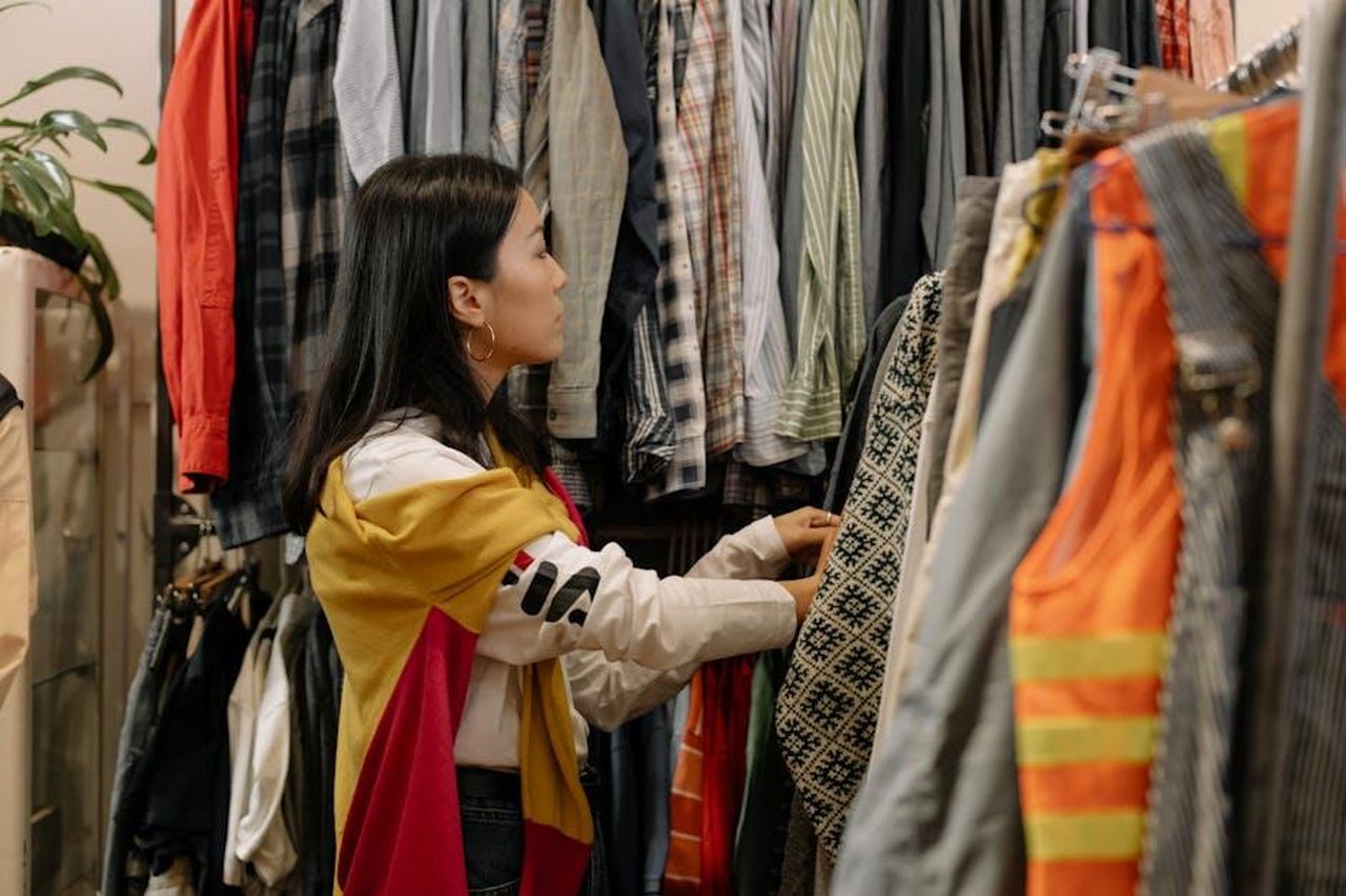 Prospettive_future_per_il_mercato_delle_auto_usate_7YmCpsQaMh - Veicoli24 Source: cottonbro studio - pexels - A young woman browsing clothes in a vintage store with colorful outfits.