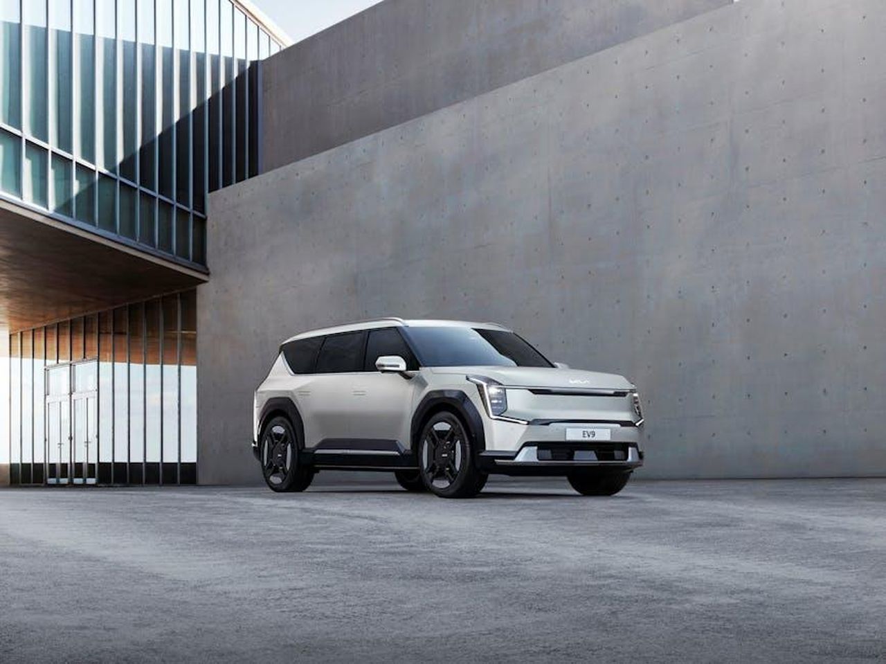 Riconoscimenti_e_Innovazioni_della_Kia_EV9_38v8KwWvbW - Veicoli24 Source: Hyundai Motor Group - pexels - Kia EV9 electric SUV parked in an urban architectural environment, showcasing modern design.