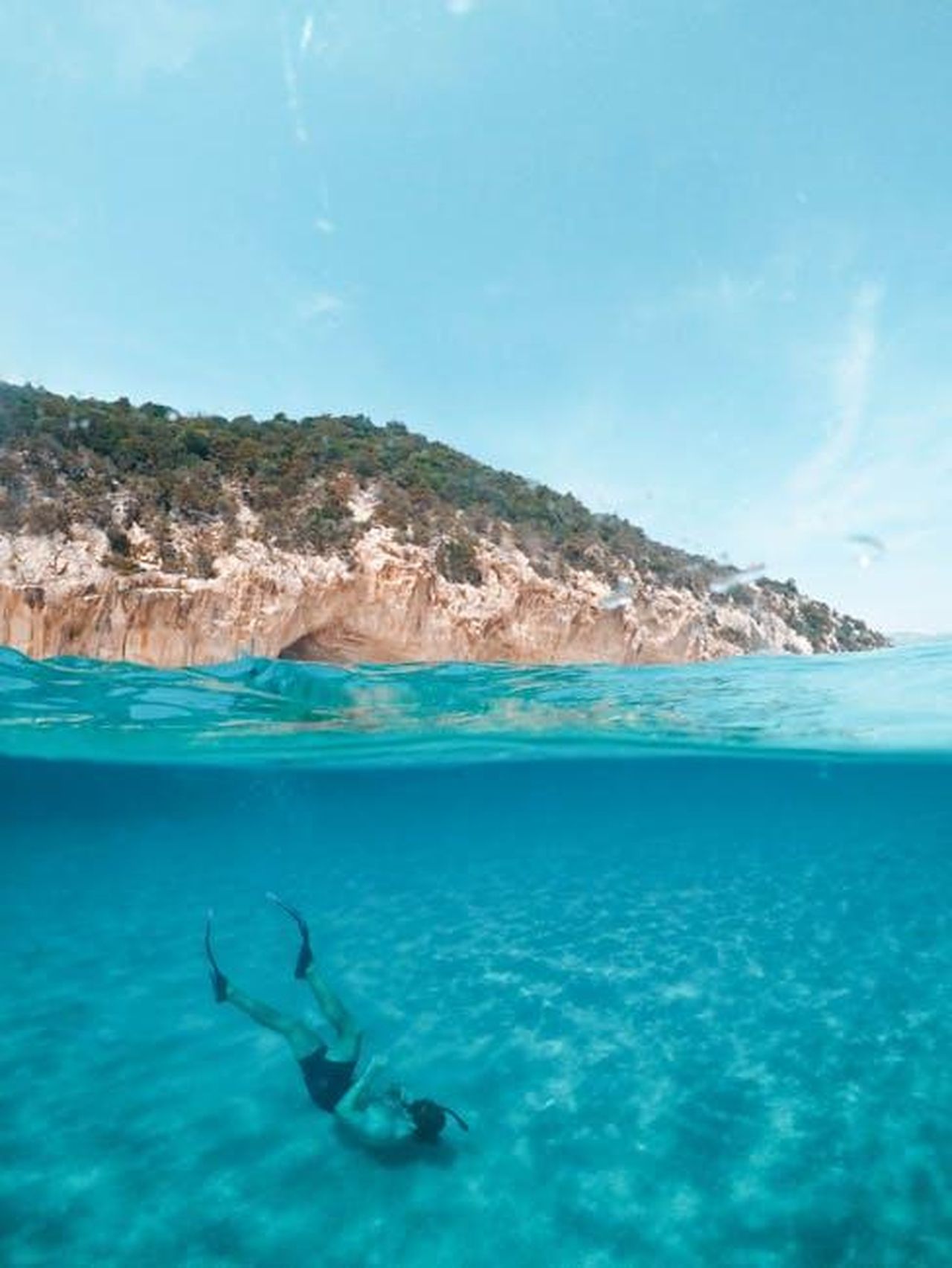 Sardegna_natura_incontaminata_e_tradizioni_tfA6a9w3RF - Veicoli24 Source: Symeon Ekizoglou - pexels - A serene over-under photograph capturing a diver exploring the turquoise waters off the coast of Sardinia, Italy.
