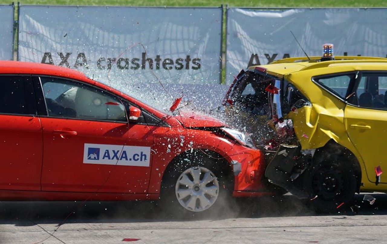 Sicurezza_e_convenienza_tT83uMd3Ea - Veicoli24 Source: Pixabay - pexels - Red and yellow cars shown in a head-on collision during a crash test for safety evaluation.