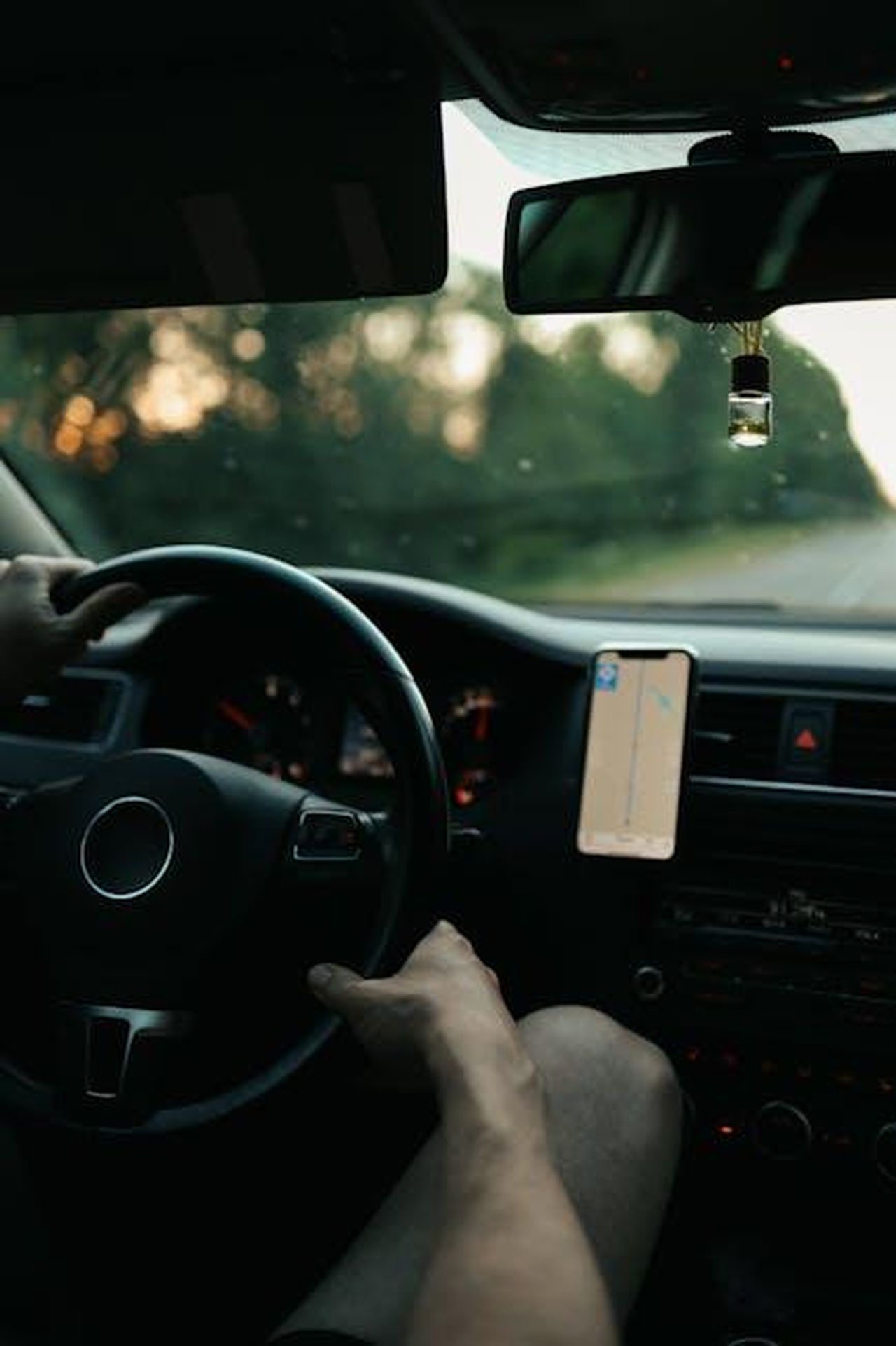 Sistemi_di_assistenza_alla_guida_MBDRIVE_QbOZYpeizH - Veicoli24 Source: Maksim Goncharenok - pexels - View from inside a car showing hands on the wheel, driving with a GPS-guided journey.