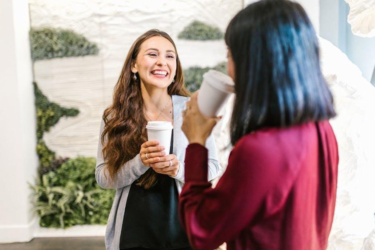 Statistiche_sulla_presenza_femminile_in_Nissan_yncuThUQr3 - Veicoli24 Source: RDNE Stock project - pexels - Two women in a modern office setting enjoying a casual coffee break, highlighting teamwork and relaxation.