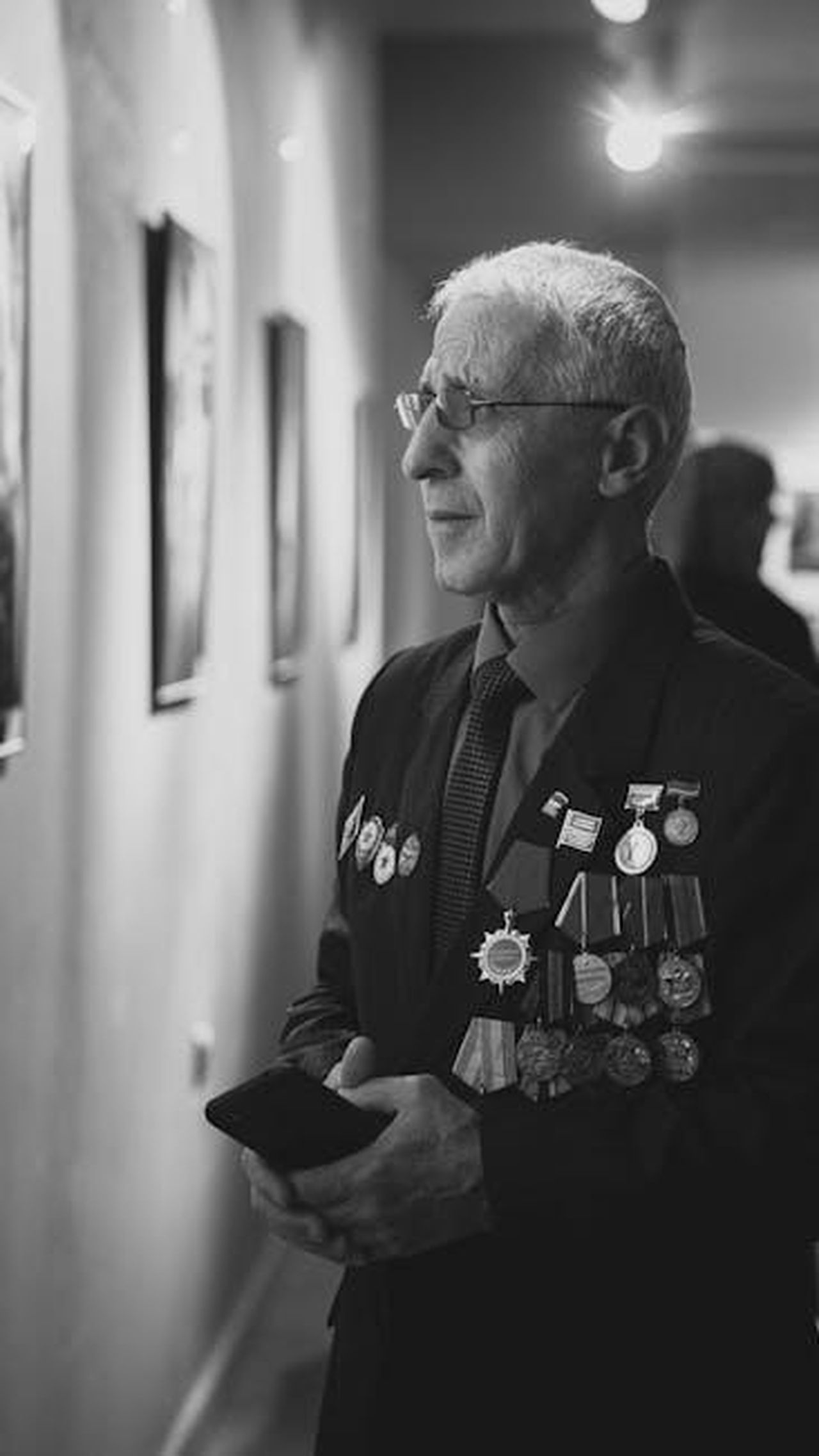 Storia_dei_riconoscimenti_Kia_ai_World_Car_Awards_FUqKSAixGV - Veicoli24 Source: Zaur Takhgiriev - pexels - Black and white portrait of an elderly man with medals in an art gallery.