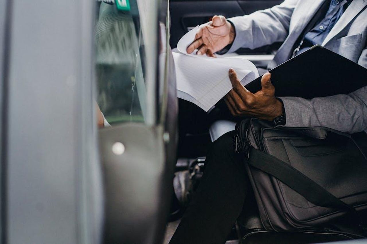 Strategia_e_Innovazione_xW9LL1XxdX - Veicoli24 Source: Ono Kosuki - pexels - Businessman reviewing documents inside a vehicle, depicting focus and professionalism.