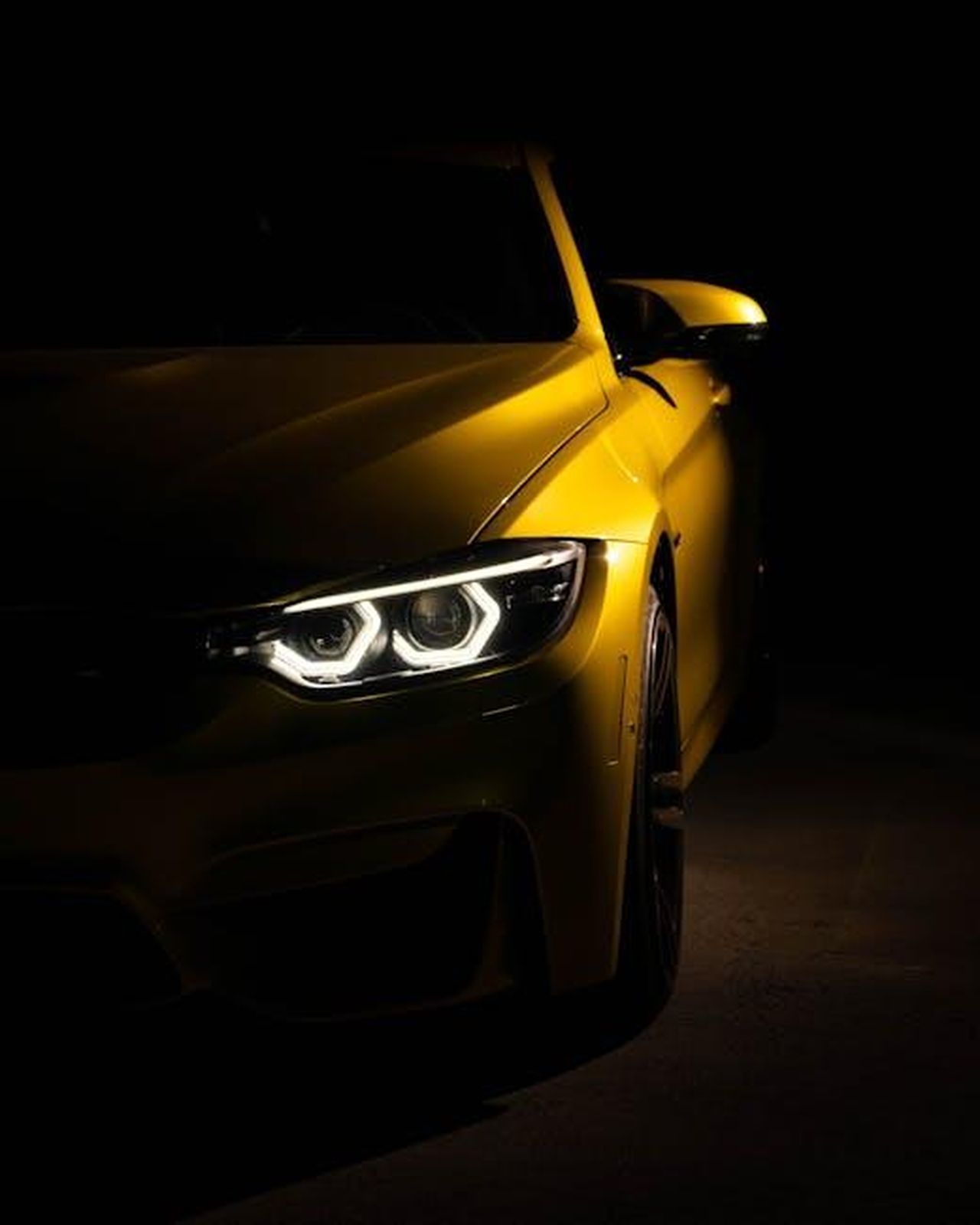 Successi_del_BMW_M4_GT4_EVO_OykcOxAmTV - Veicoli24 Source: Miguel Mallari - pexels - A striking yellow sports car captured with headlights on in moody low light setting.