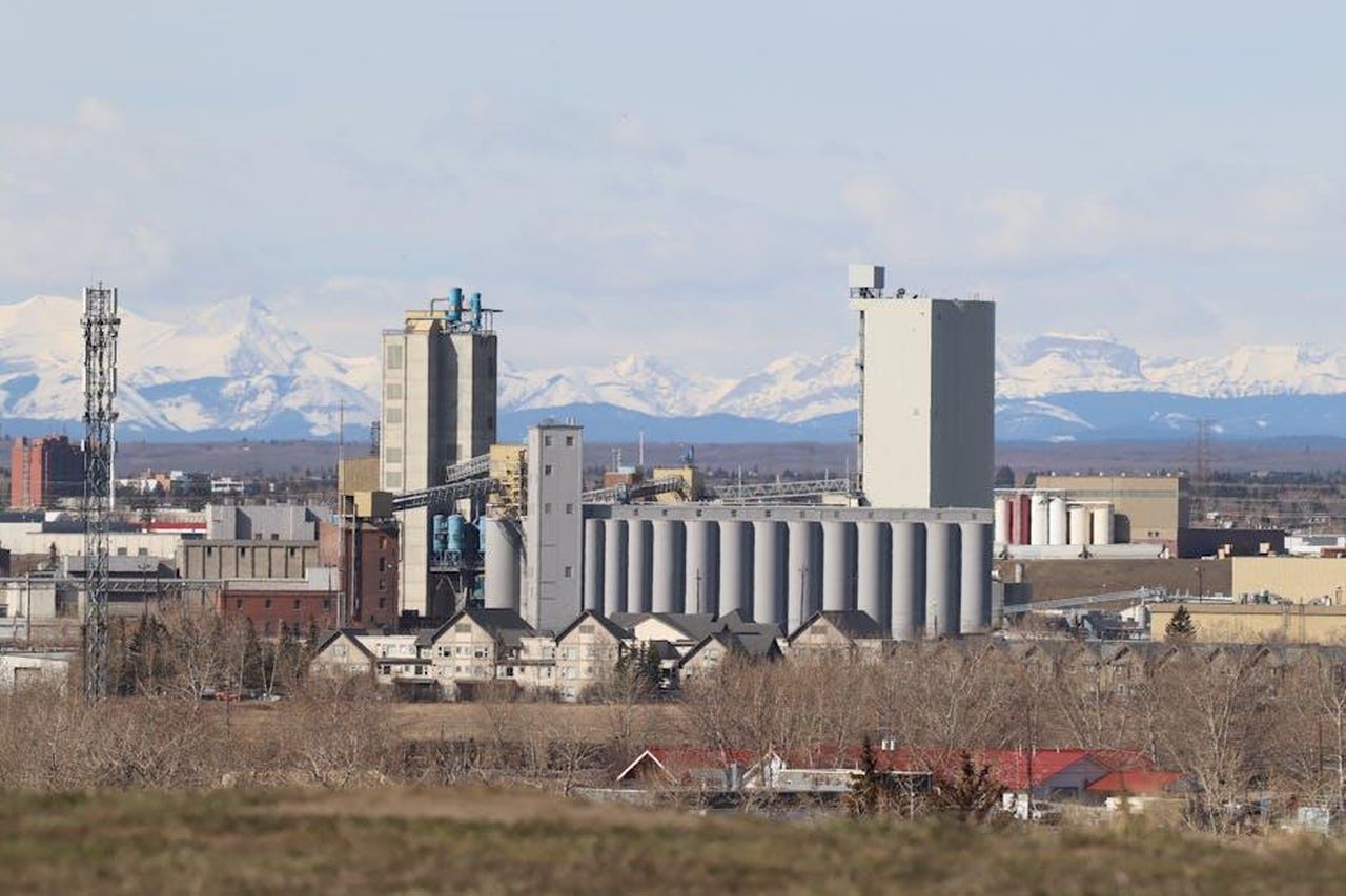 Sviluppo_e_implementazione_5tBTEUbVBh - Veicoli24 Source: Francois Mutombo - pexels - Industrial area in Calgary with Rocky Mountains backdrop, showcasing urban development.