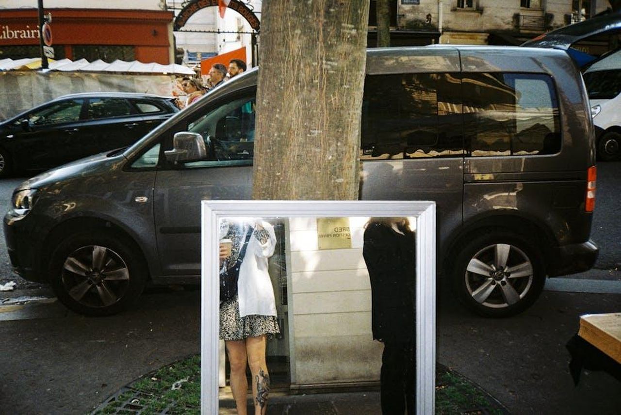 Tendenze_di_vendita_in_Francia_gvF8CPhSSD - Veicoli24 Source: Darya Sannikova - pexels - A city street scene with a car reflected in a mirror, capturing urban life essence.